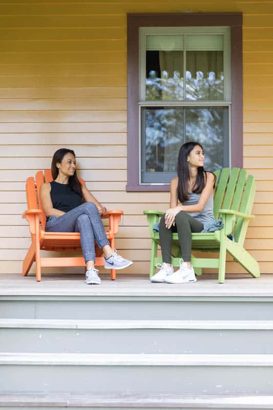 2 woman sitting on chairs outside